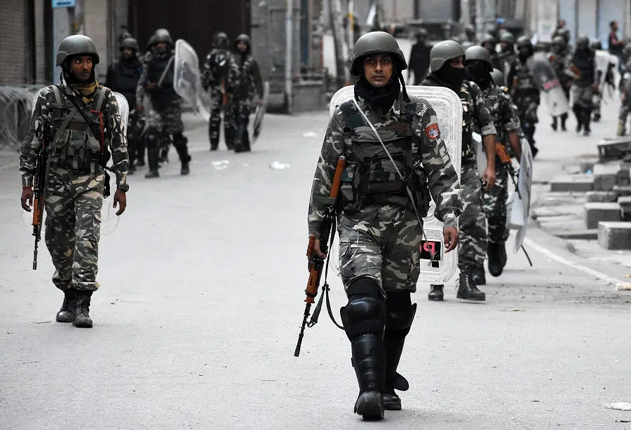 Security forces in camouflage patrolling an urban area in Kashmir, indicative of preventive detention enforcementÂ