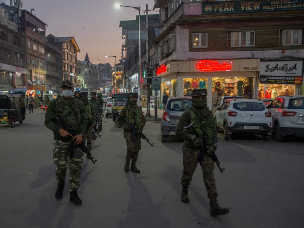 Armed paramilitary personnel patrol a street in Jammu and Kashmir reflecting a strong security presence