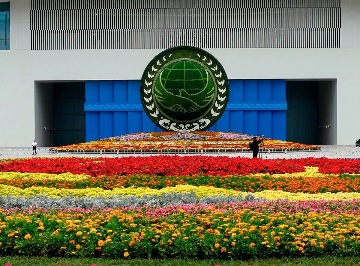 Venue of the SCO Summit 2025 in Tianjin, China, featuring the organization's emblem and vibrant floral arrangements