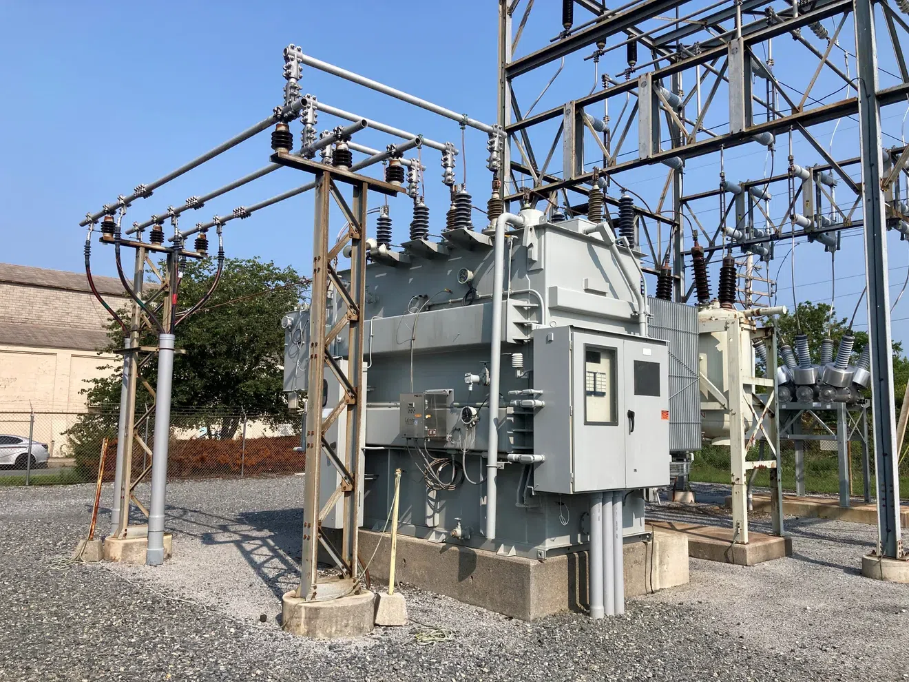 Electrical transformer installation at an outdoor substation with surrounding high-voltage components